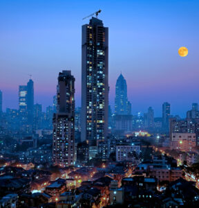 Moonrise over south central Mumbai - the financial capital of India - showing a glittering metropolis with a reputation of city that never sleeps with dwellings of lower middle class in foreground and newer towers where elite stay in the far background.