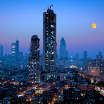 Moonrise over south central Mumbai - the financial capital of India - showing a glittering metropolis with a reputation of city that never sleeps with dwellings of lower middle class in foreground and newer towers where elite stay in the far background.