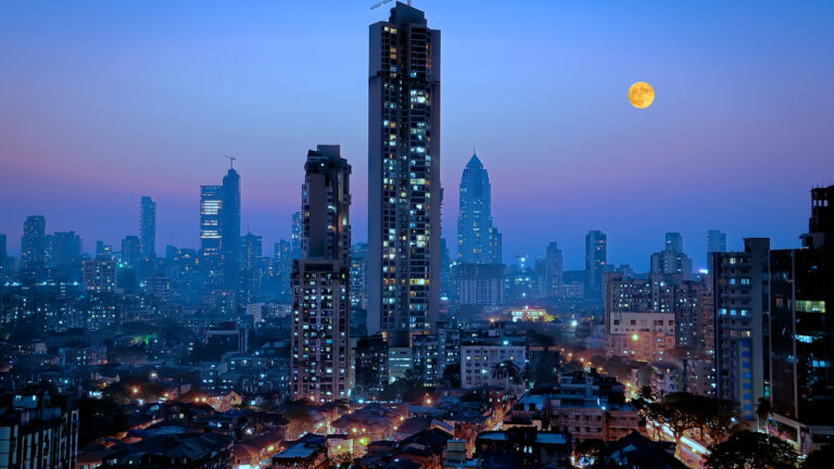 Moonrise over south central Mumbai - the financial capital of India - showing a glittering metropolis with a reputation of city that never sleeps with dwellings of lower middle class in foreground and newer towers where elite stay in the far background.