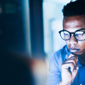 Man wearing glasses staring at computer screen